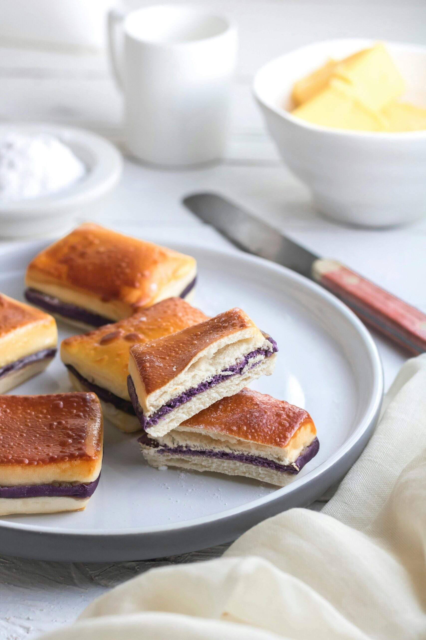 Petits pains fourrés à la crème d’ube servis dans une assiette