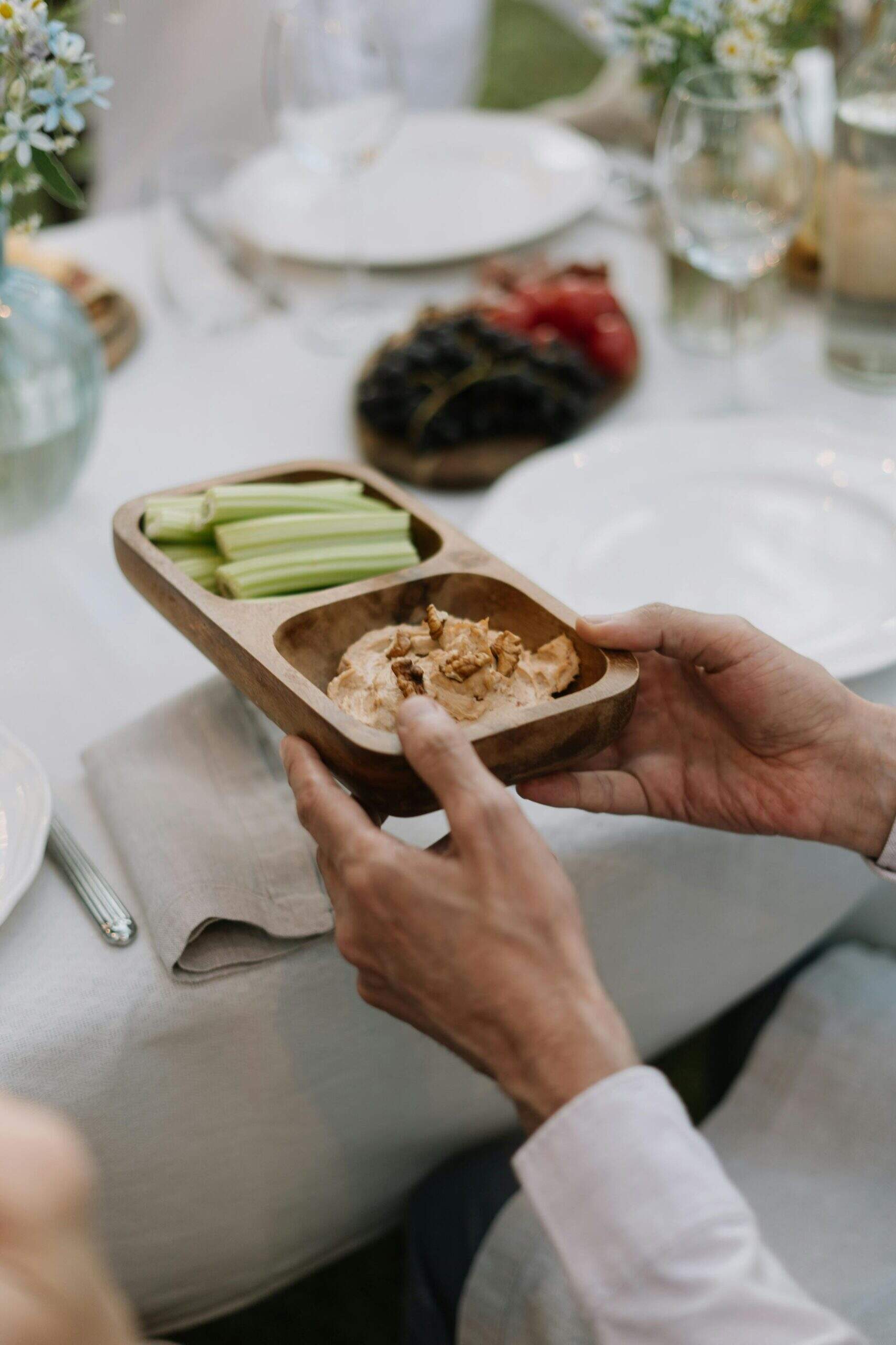 Mains tenant un plateau en bois contenant des bâtonnets de céleri et une trempette garnie de noix, lors d’un repas à table.Mains tenant un plateau en bois contenant des bâtonnets de céleri et une trempette garnie de noix, lors d’un repas à table.

Demander à ChatGPT

