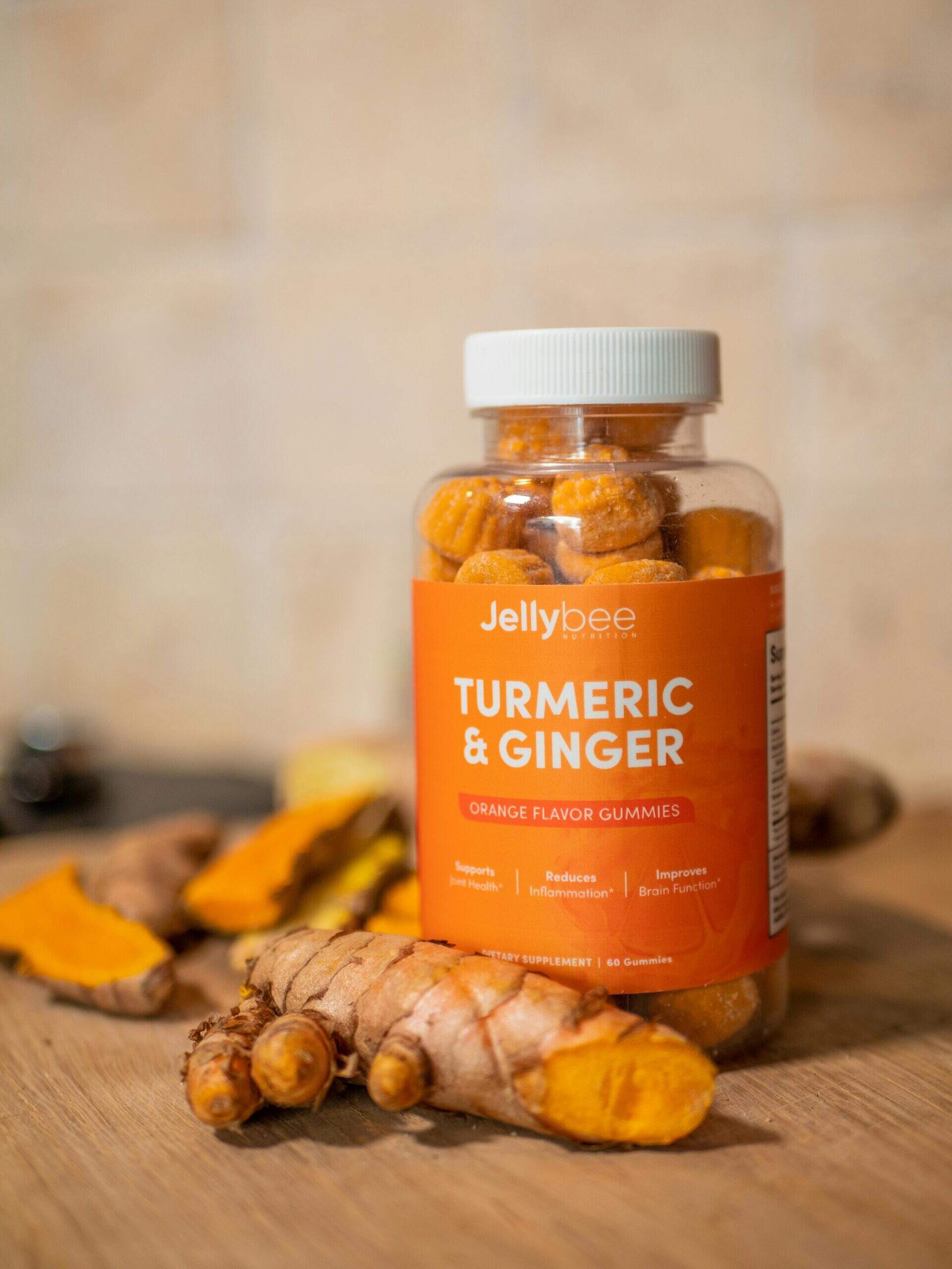 Bouteille de compléments Jellybee curcuma et gingembre avec racines fraîches autour