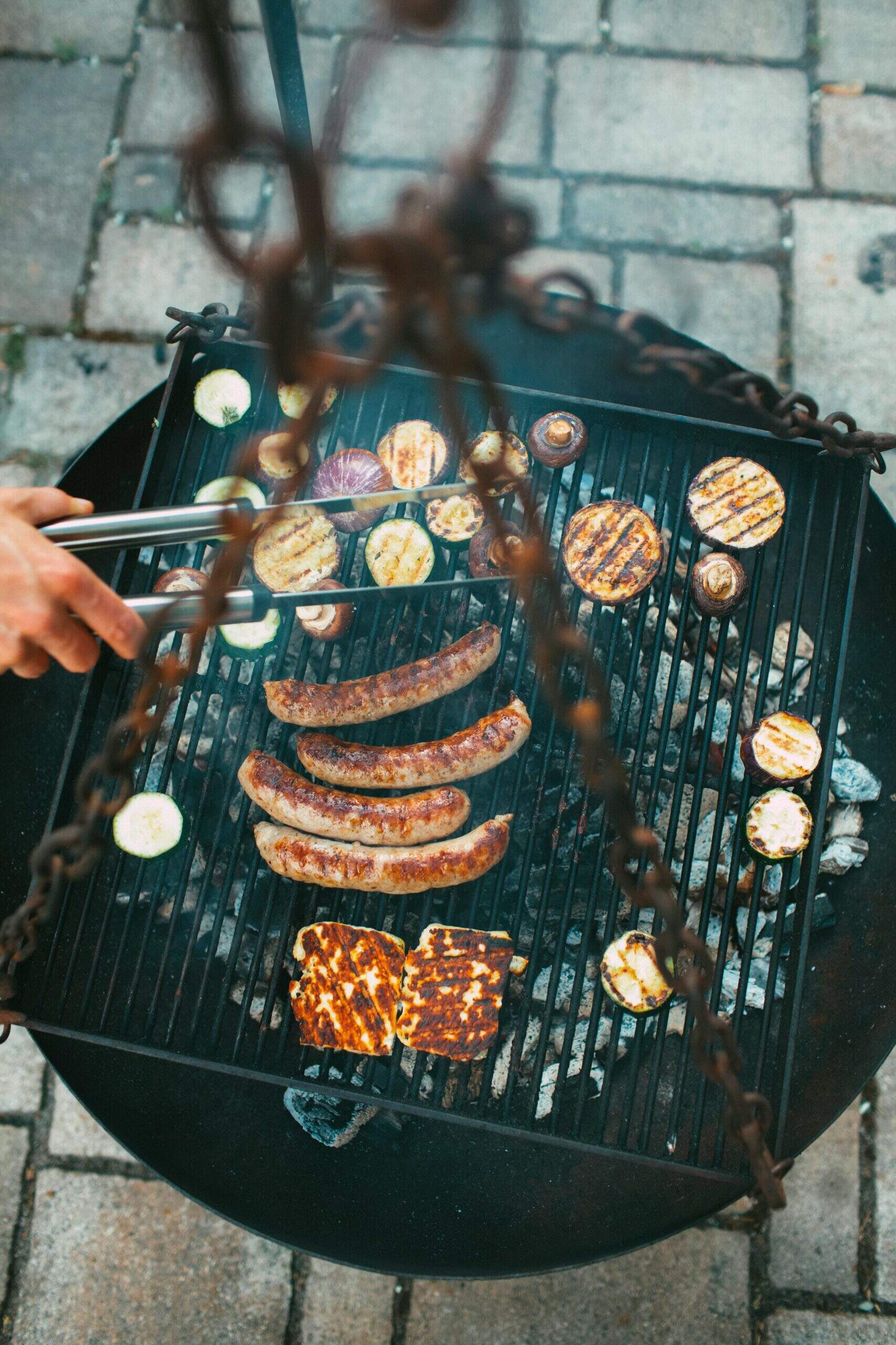 Barbecue avec saucisses et légumes grillés, photographié en plongée