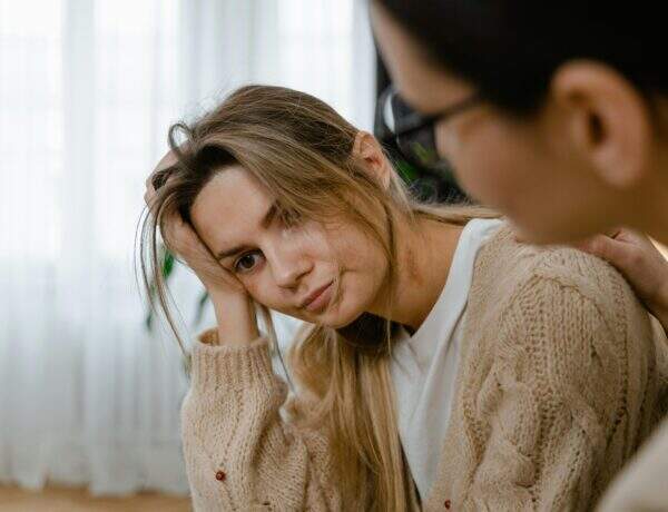 deux femmes dont une semble désespérée et l'autre pose sa main sur son épaule