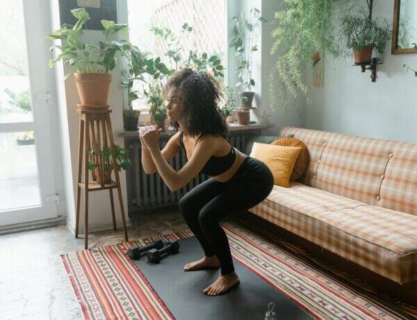 Femme faisant des squats dans son salon