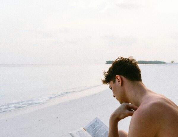 Homme lisant un livre sur la plage