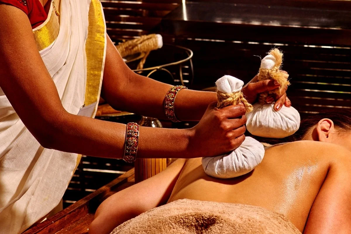 Praticien en ayurvéda durant une séance de massage ayurvédique avec un client.