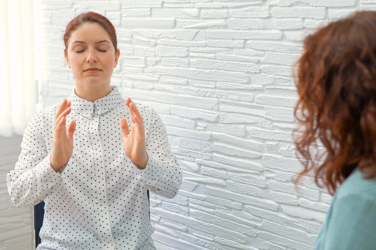 Client entrain de pratiquer la sophrologie durant une séance avec un sophrologue.