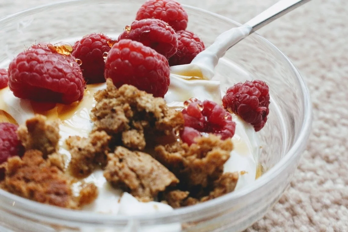 skyr-medoucine-2 Bol de skyr avec des framboises, céréales et coulis de caramel.