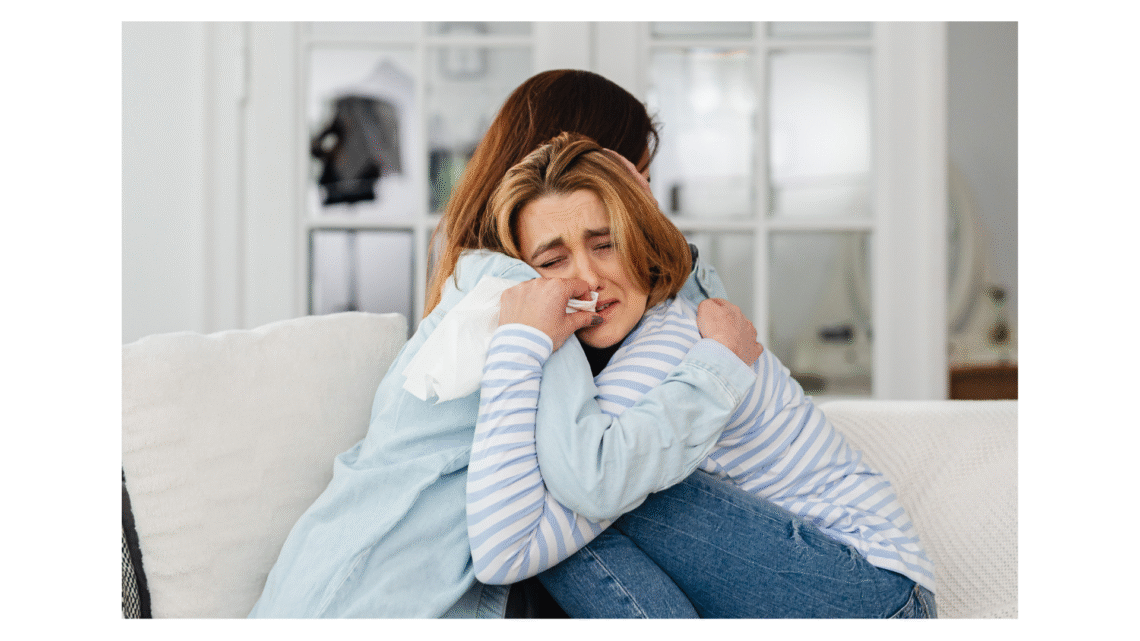 Femme qui pleure dans les bras de son amie car elle a perdu son bébé