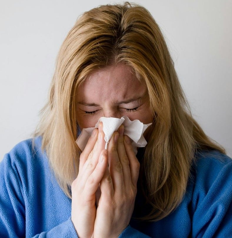 jeune femme allergique se mouchant