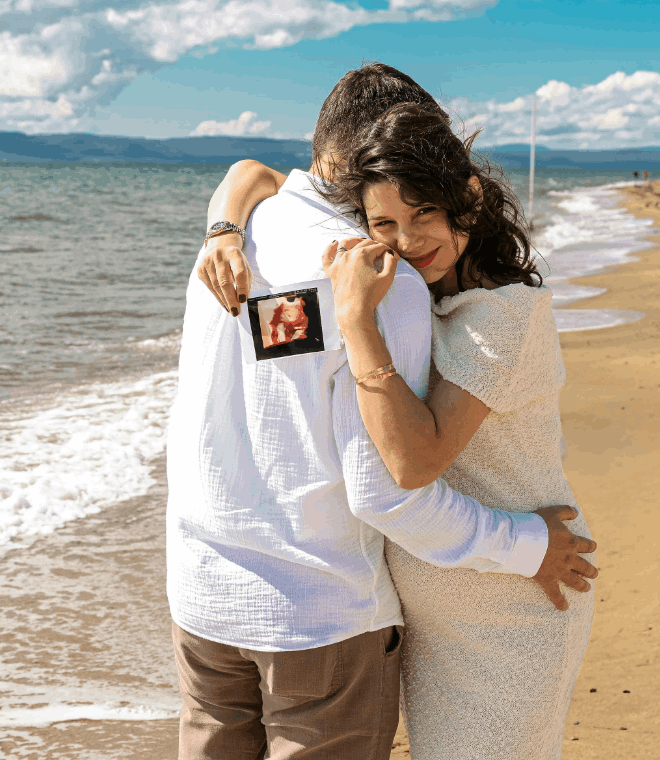futurs parents heureux enlacés et heureux à la plage