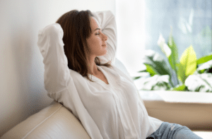 jeune femme détendue assise sur un canapé