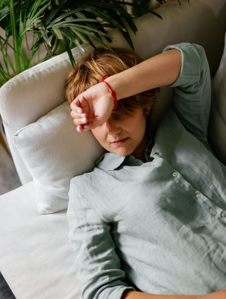 femme fatiguée au repos sur un canapé