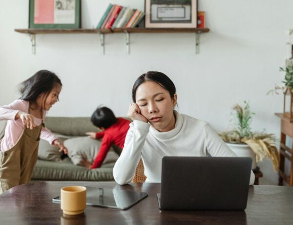 jeune maman lasse et fatiguée devant l'ordinateur avec ses enfants