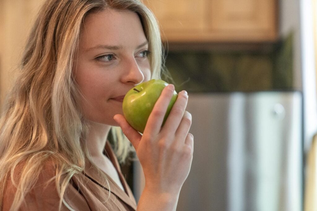 femme s'apprêtant à déguster une belle pomme verte