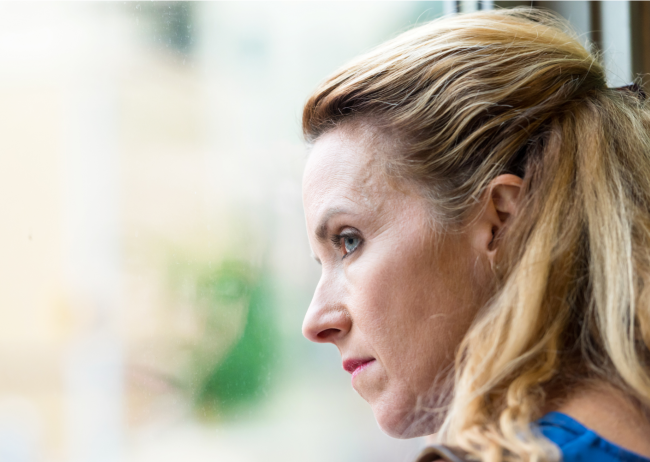 Femme pensive regardant à la fenêtre