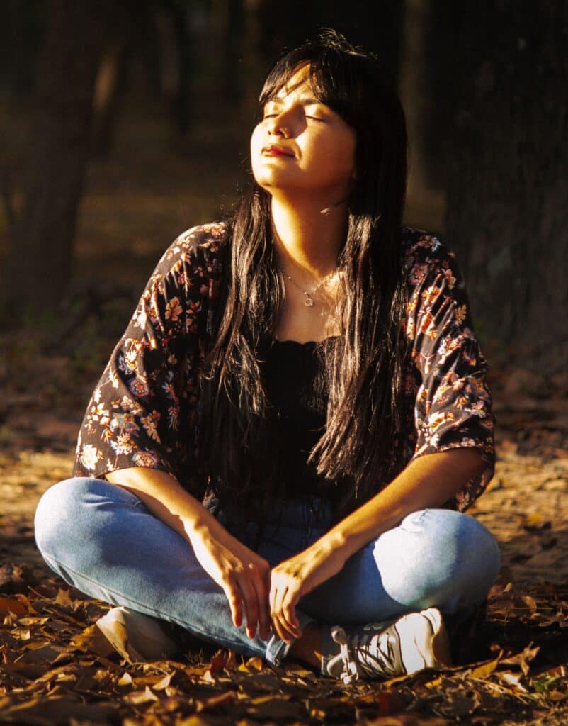 jeune femme se relaxant les yeux fermés dans la nature