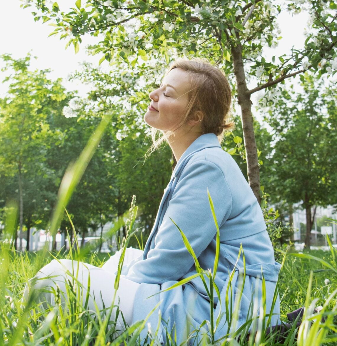 femme en état de flow prenant un temps de détente dans la nature