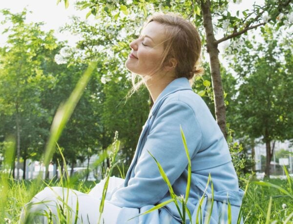 femme en état de flow prenant un temps de détente dans la nature