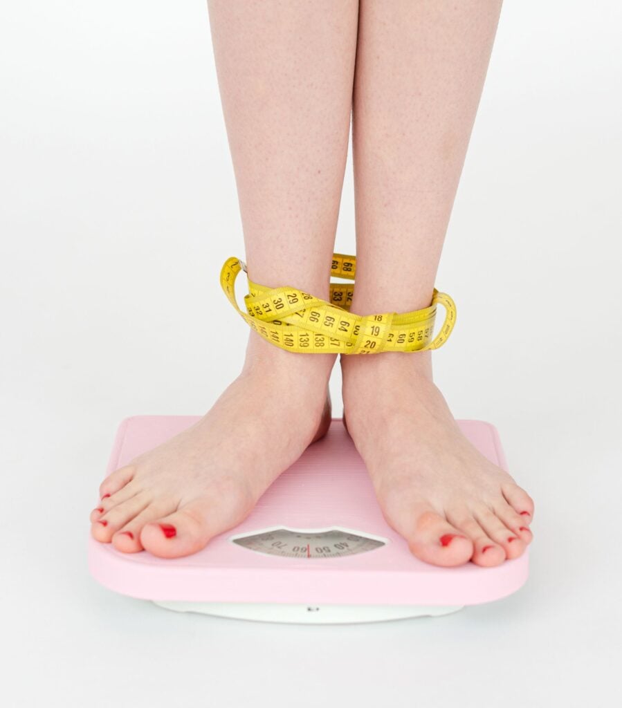 femme sur une balance avec un ruban de poids