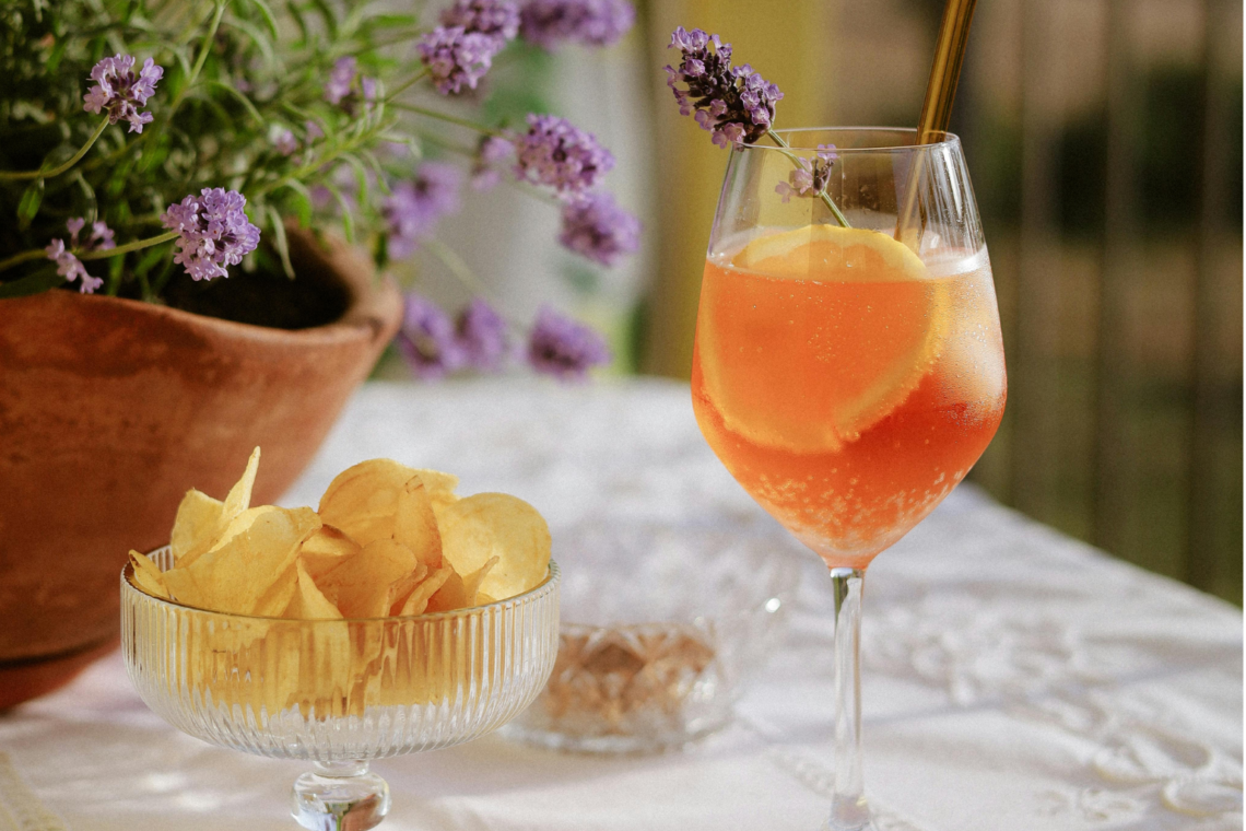 verre d'aperol spritz en terrasse pour l'été avec une coupelle de chips