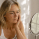 Une femme qui a peur de vieillir et qui regarde ses rides dans le miroir